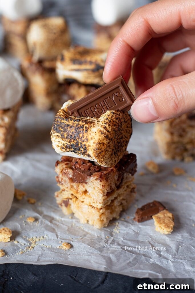 Placing a piece of Hershey's on a toasted marshmallow.