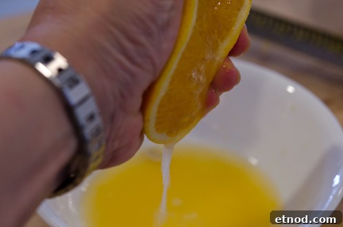 Soft Ginger Cookies with Orange Glaze Recipe 12 Orange juice being squeezed out.