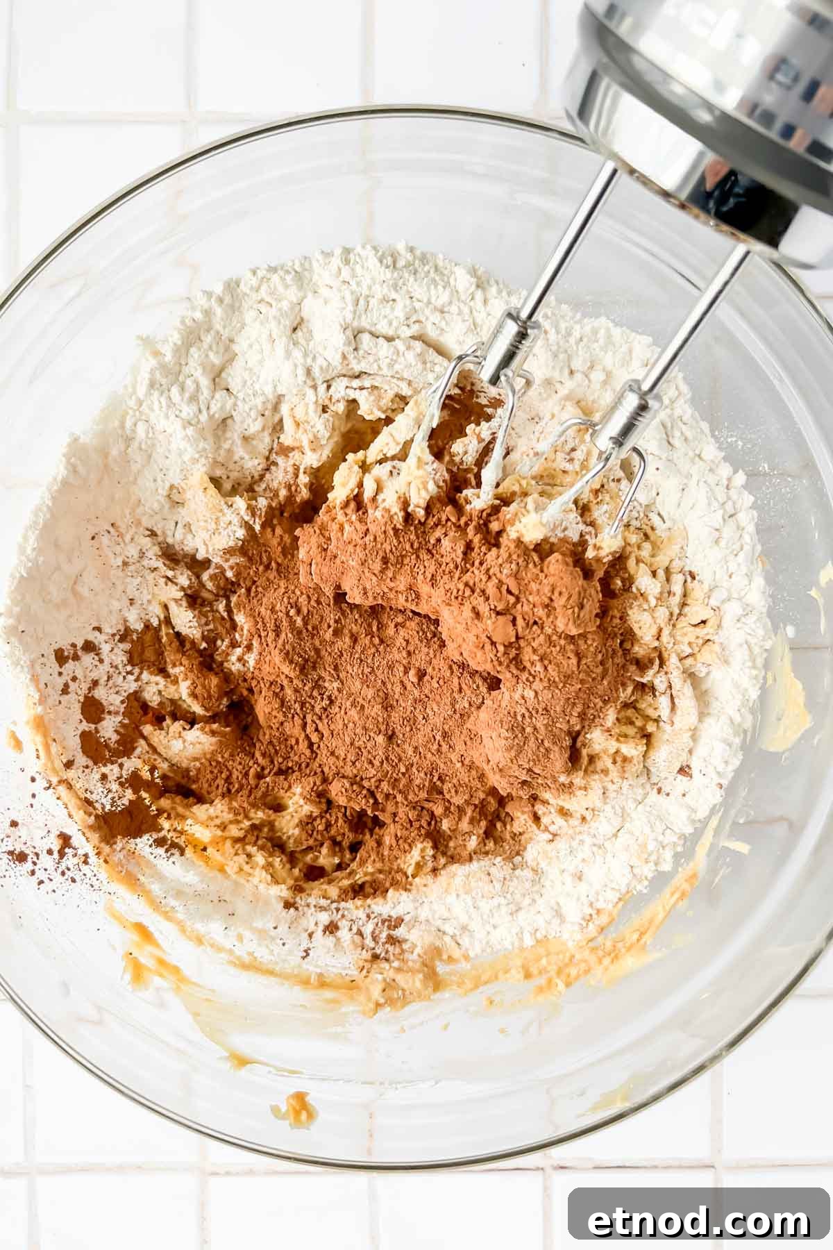 Chocolate Peppermint Kiss Cookies Recipe for Holiday Baking 6 dry ingredients for chocolate peppermint kiss cookies in glass mixing bowl with electric hand mixer.