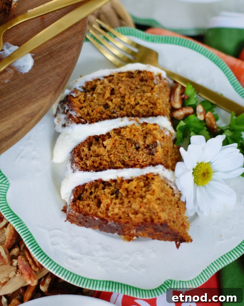 A slice of 3 layer carrot cake to show off the layers, texture of the cake and frosting.