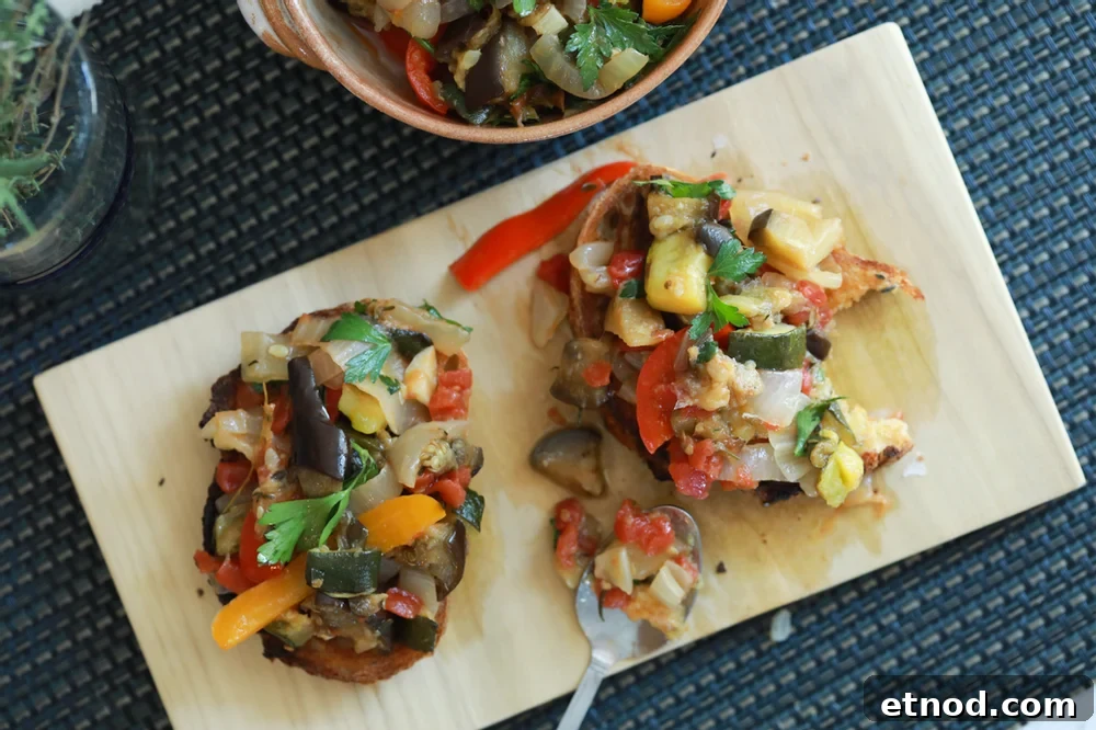 Irresistible taste with the perfect textures ratatouille tartine on a wood cutting board.