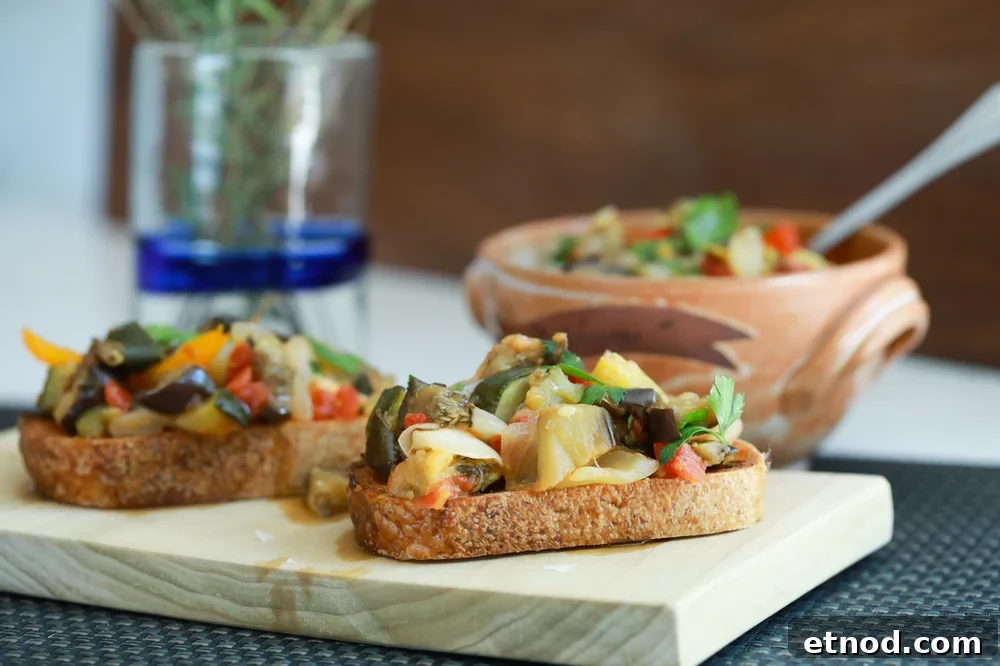 Stunning presentation and healthy eating ratatouille tartine on a wood cutting board.