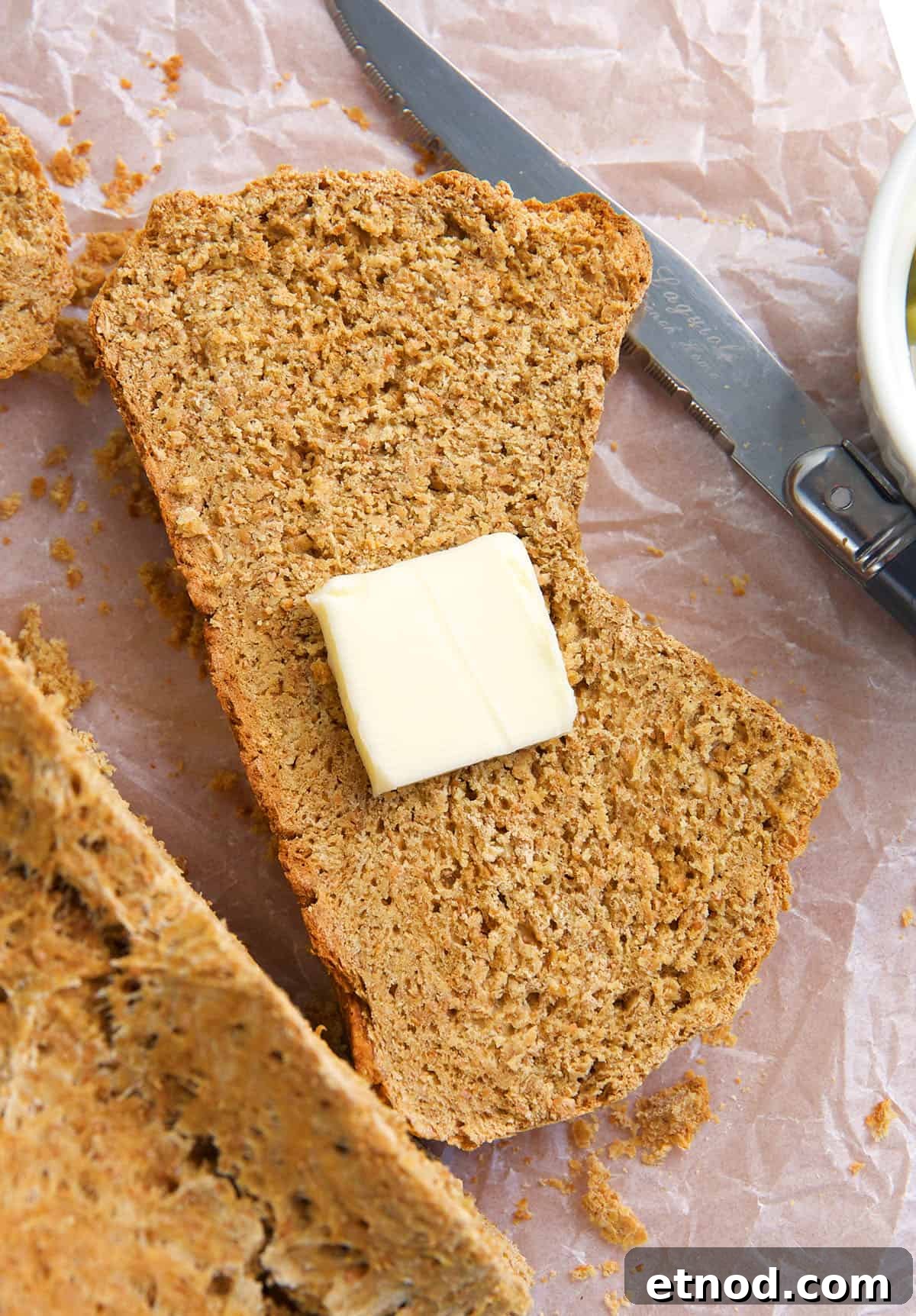 Traditional Irish Brown Bread Recipe — Rustic Soda Bread Guide 2 A single piece of brown bread has a square of butter on it.