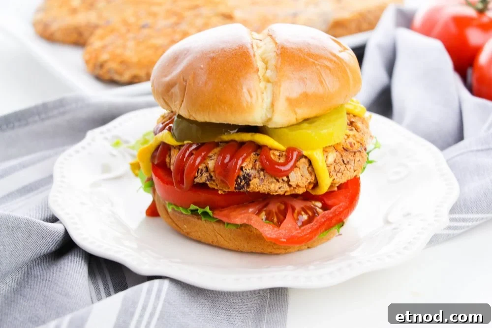 pinto bean burger on bun with lettuce, tomato, pickles and condiments
