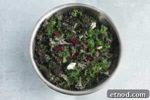 Kale Salad with Roasted Beets and Orange Vinaigrette 14 This is a picture of a bowl with the kale salad being tossed.