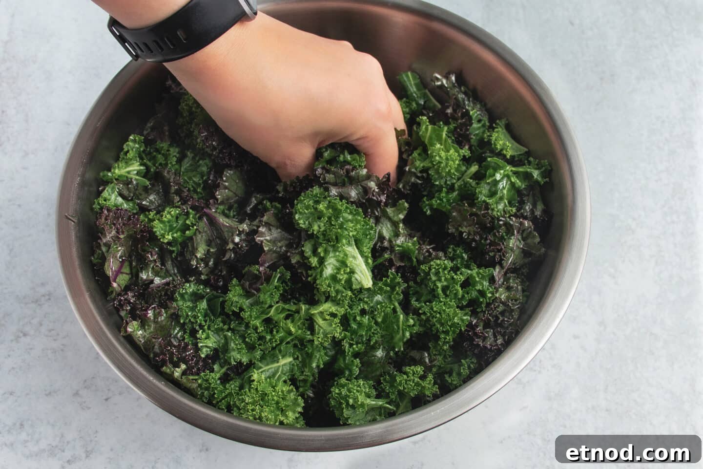 Kale Salad with Roasted Beets and Orange Vinaigrette 5 Picture of kale in a large bowl being massaged.