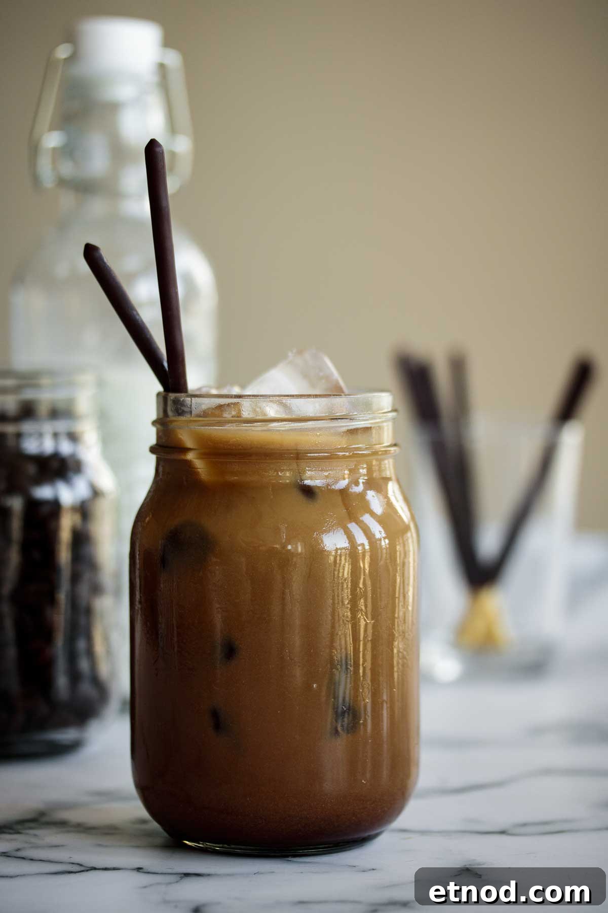 Iced Chocolate Almond Milk Shaken Espresso Recipe 2 Iced Chocolate Almond Milk Shaken Espresso served in a mason jar with chocolate sticks for styling.
