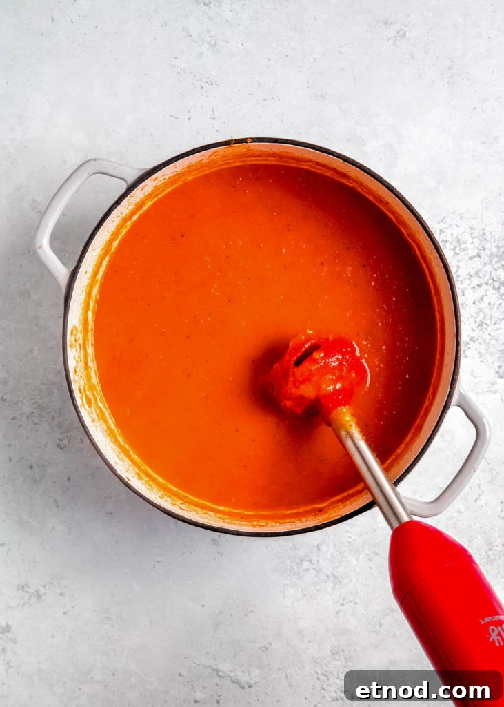 Creamy Roasted Red Pepper Soup with Garlic and Basil 11 immersion blender in a pot full of roasted red pepper soup