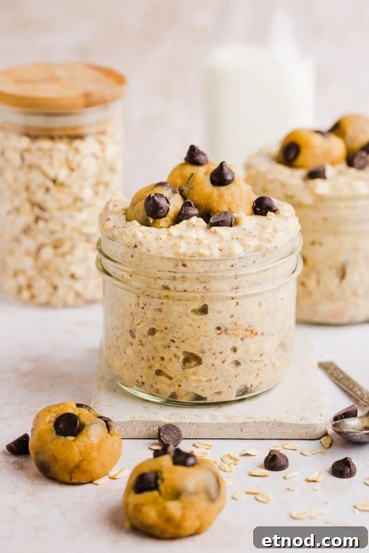 Cookie dough overnight oats with protein in a glass jar, topped with chocolate chips.