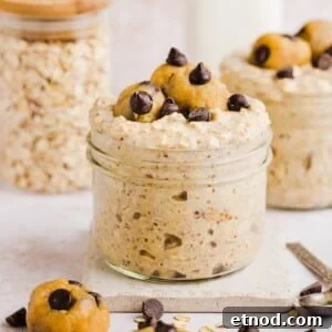 Cookie dough overnight oats with protein in a glass jar, topped with chocolate chips.
