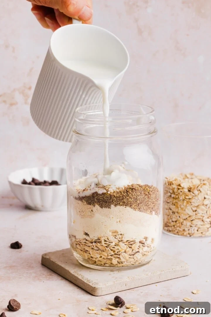Ingredients for cookie dough overnight oats in a glass jar.
