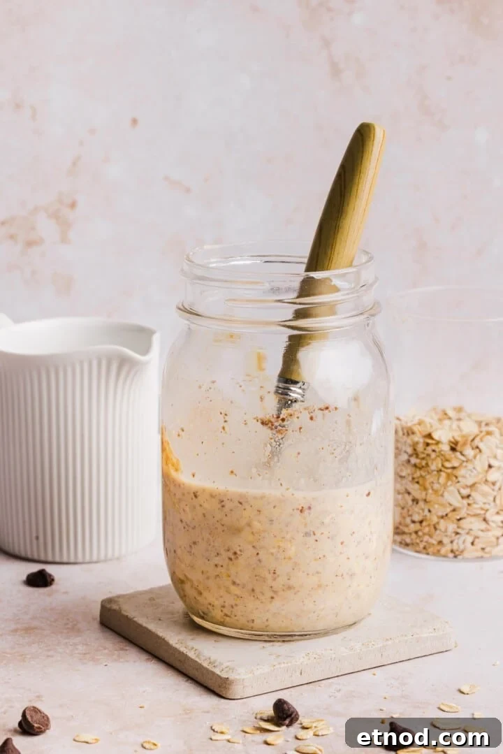 Stirred cookie dough overnight oats in a glass jar.