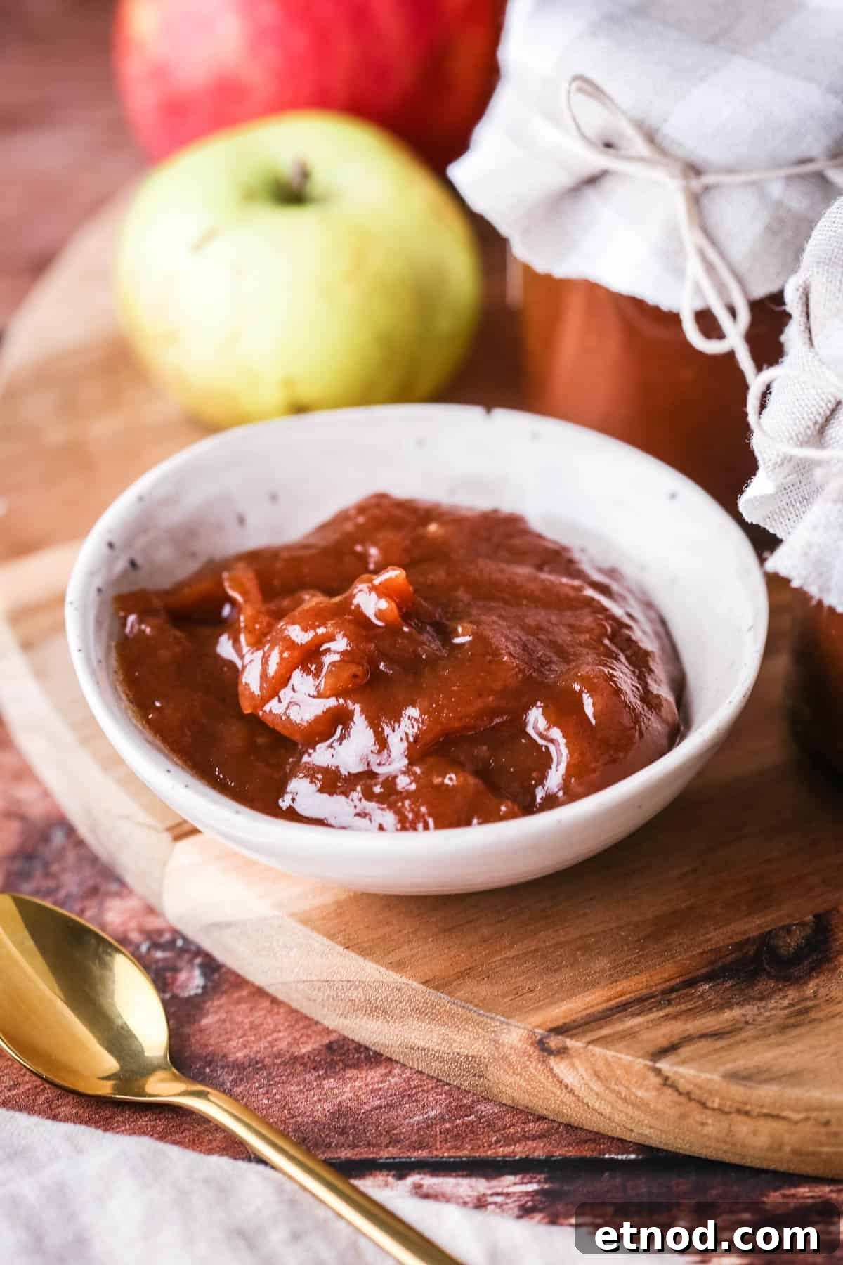 Homemade Oven-Baked Apple Butter Recipe for Spreads & Gifts 2 A small dish full of richly glossy thick apple butter.
