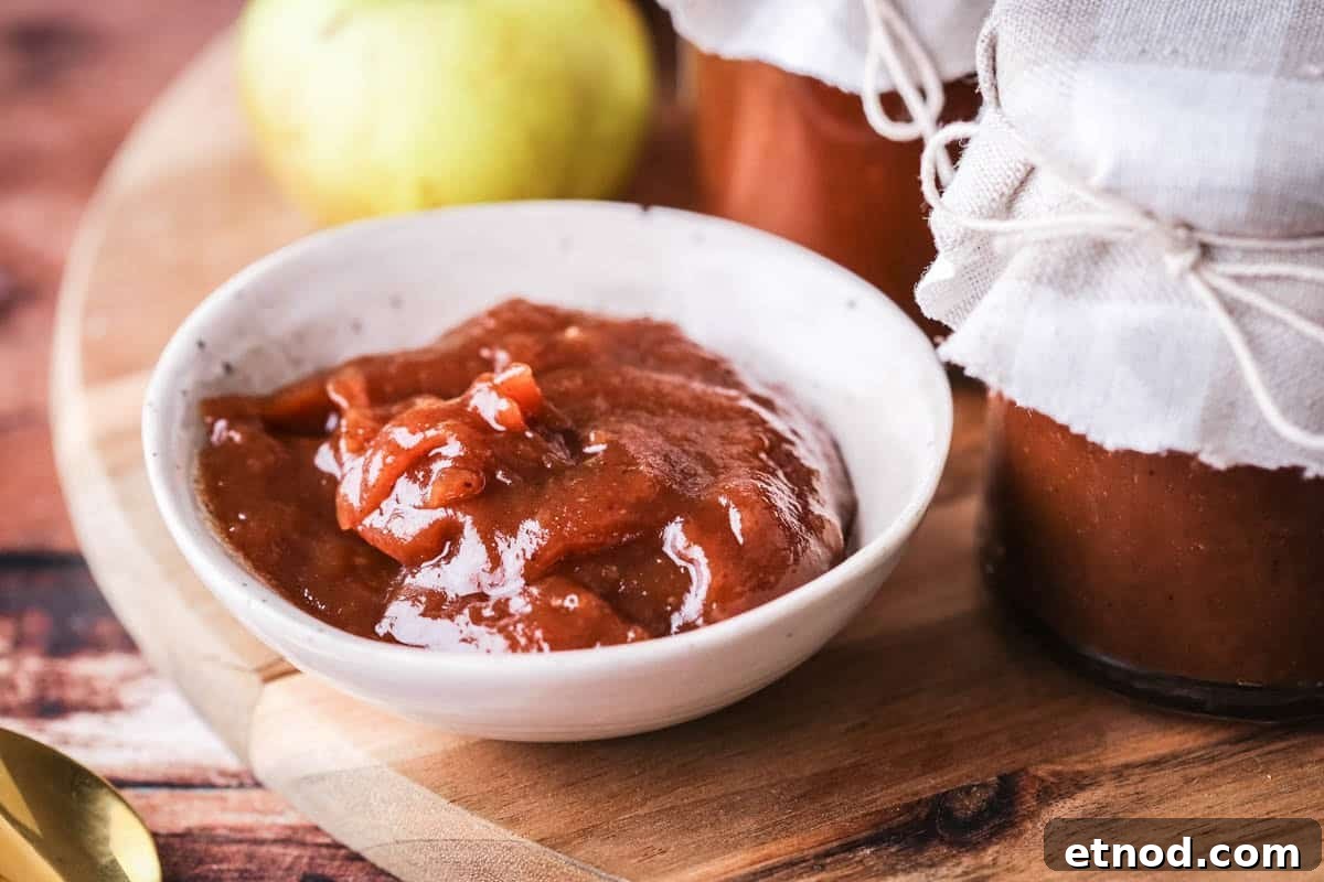 Homemade Oven-Baked Apple Butter Recipe for Spreads & Gifts 11 A small dish full of richly glossy thick apple butter.