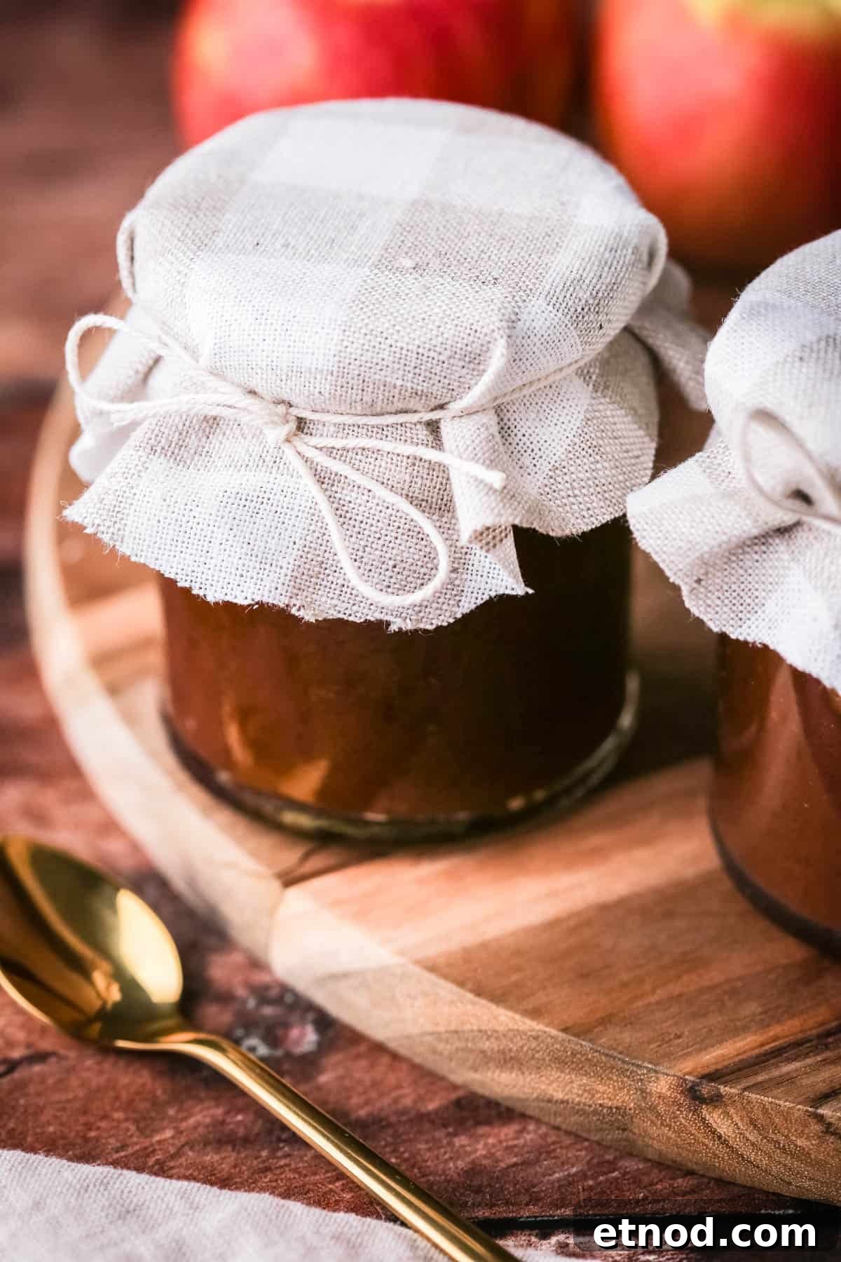 Homemade Oven-Baked Apple Butter Recipe for Spreads & Gifts 9 Apple Butter in a jar, sealed prettily with material tied around the jar for gifting.