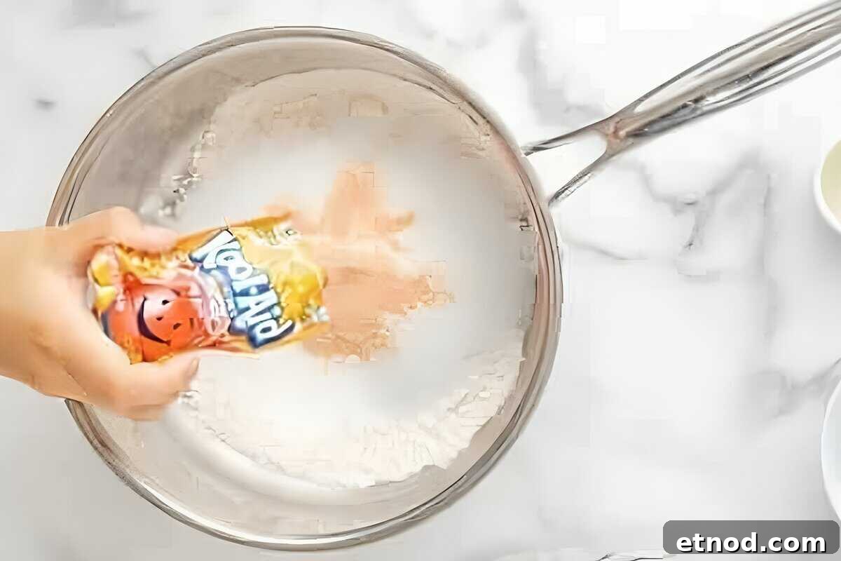 Make Homemade Kool-Aid Play Dough: Bright, Scented Recipe 11 Adding Kool-Aid powder to a saucepan with flour.