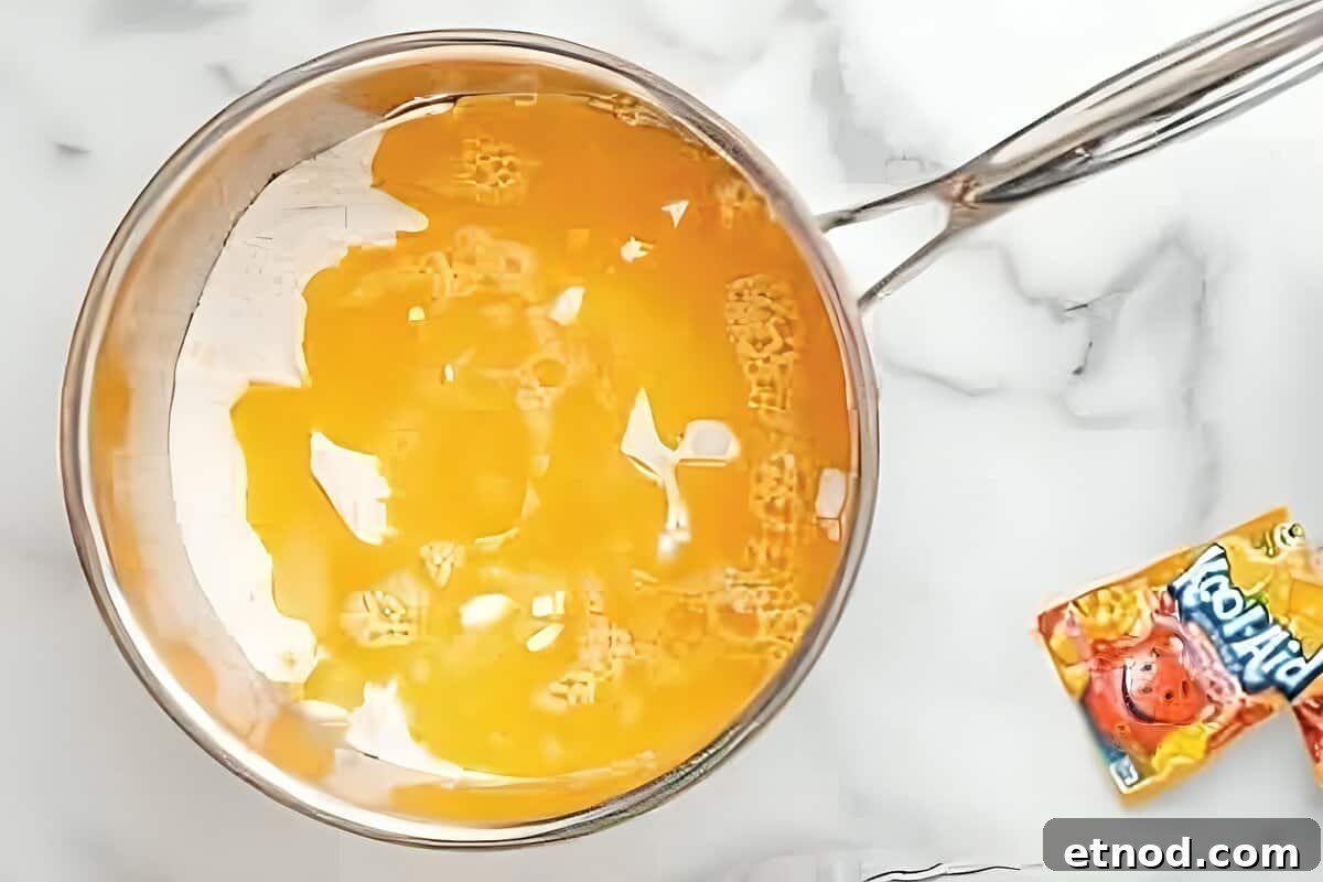 Make Homemade Kool-Aid Play Dough: Bright, Scented Recipe 12 Water and oil added to a pan of Kool-aid powder.