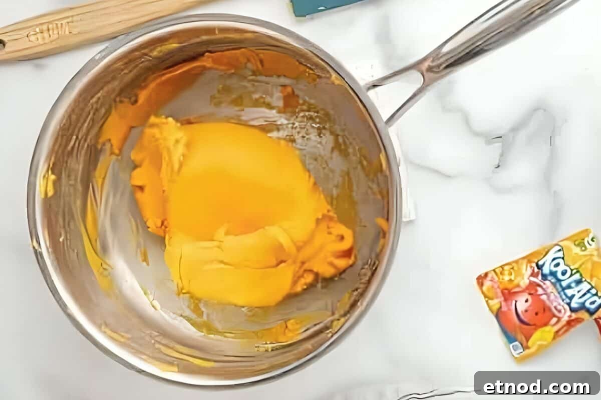 Make Homemade Kool-Aid Play Dough: Bright, Scented Recipe 13 Orange dough coming together in a pan.