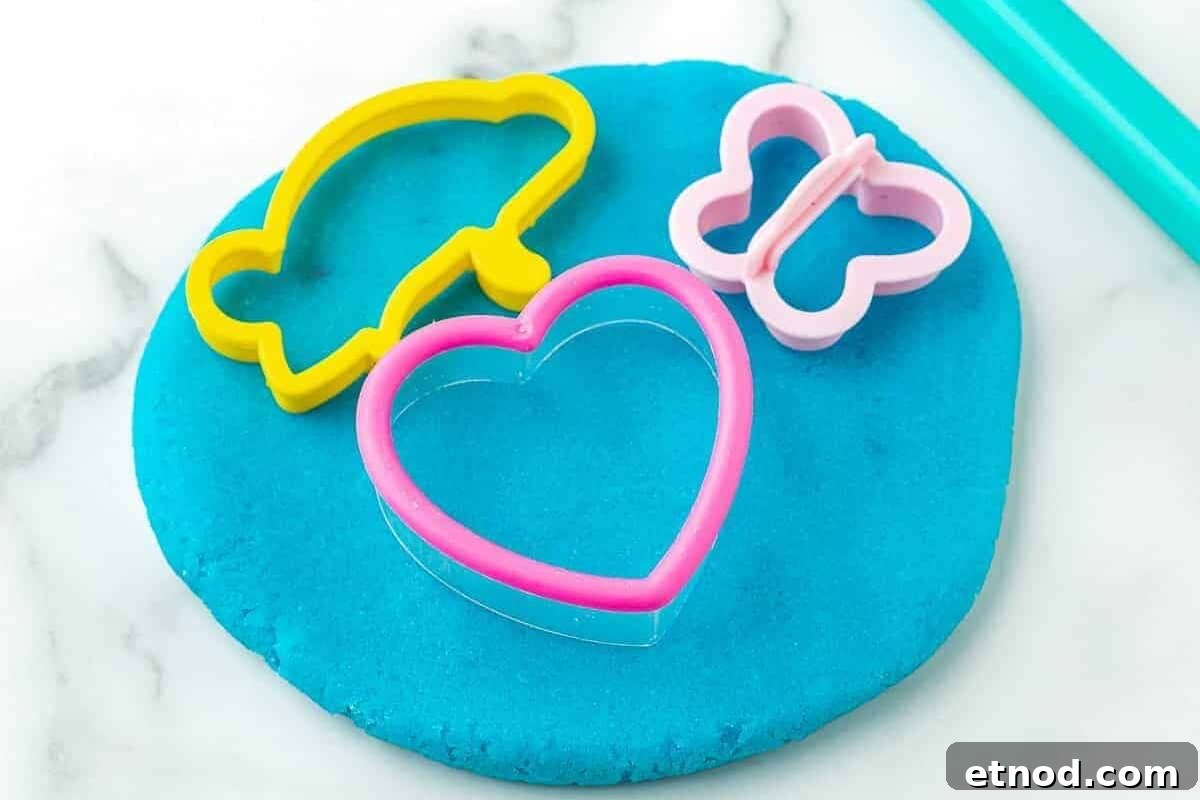 Make Homemade Kool-Aid Play Dough: Bright, Scented Recipe 3 A piece of homemade playdough with cut-out shapes.