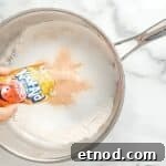 Make Homemade Kool-Aid Play Dough: Bright, Scented Recipe 5 Adding Kool-Aid powder to a saucepan with flour.
