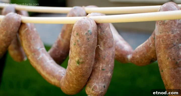 A string of homemade beer bratwurst sausages hanging on a dowel.