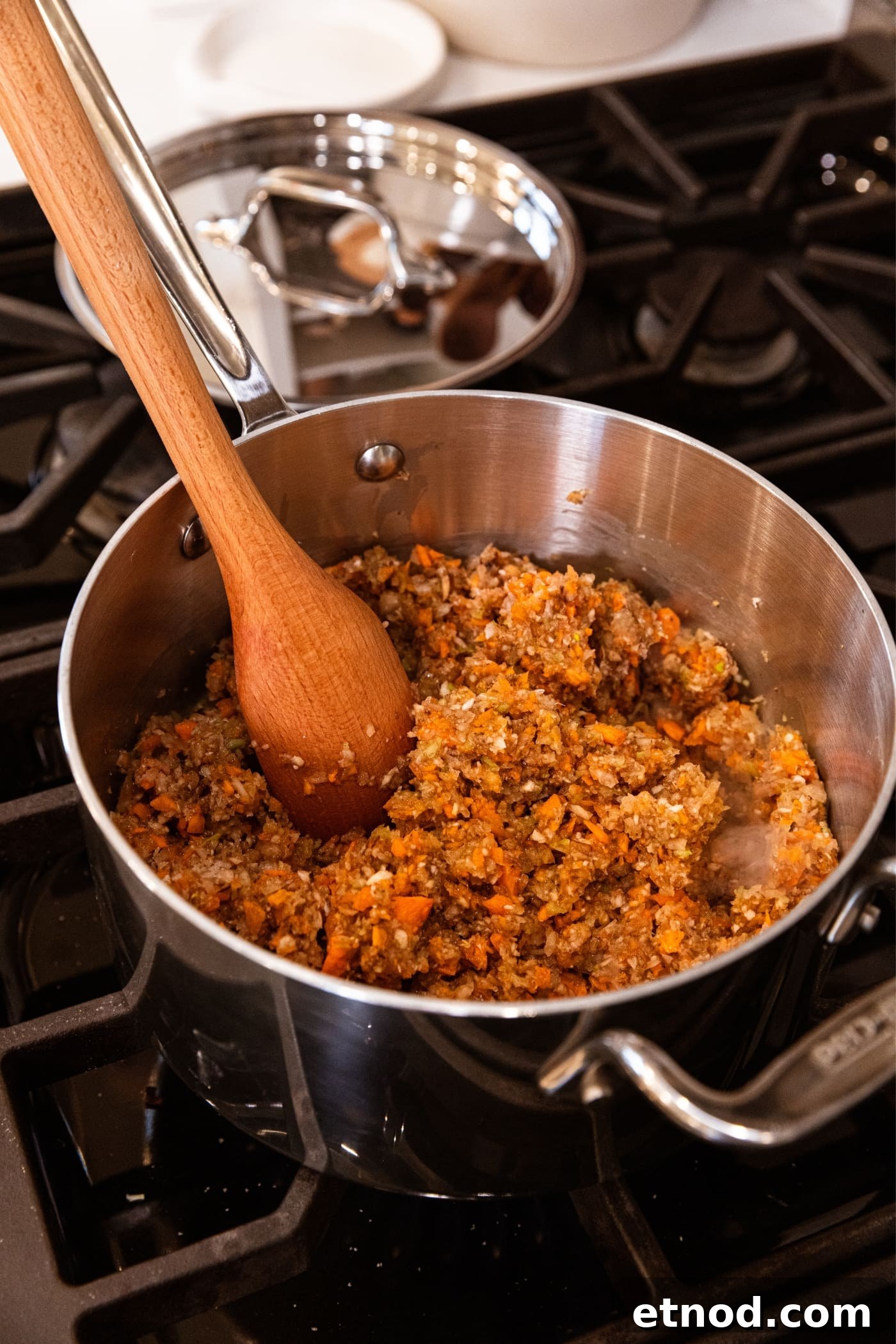 Classic Comfort Meatloaf Recipe for Perfect Weeknight Dinners 10 Wooden spoon sitting in metal stockpot filled with tomato paste mixed with vegetable mixture after being ground in food processor.