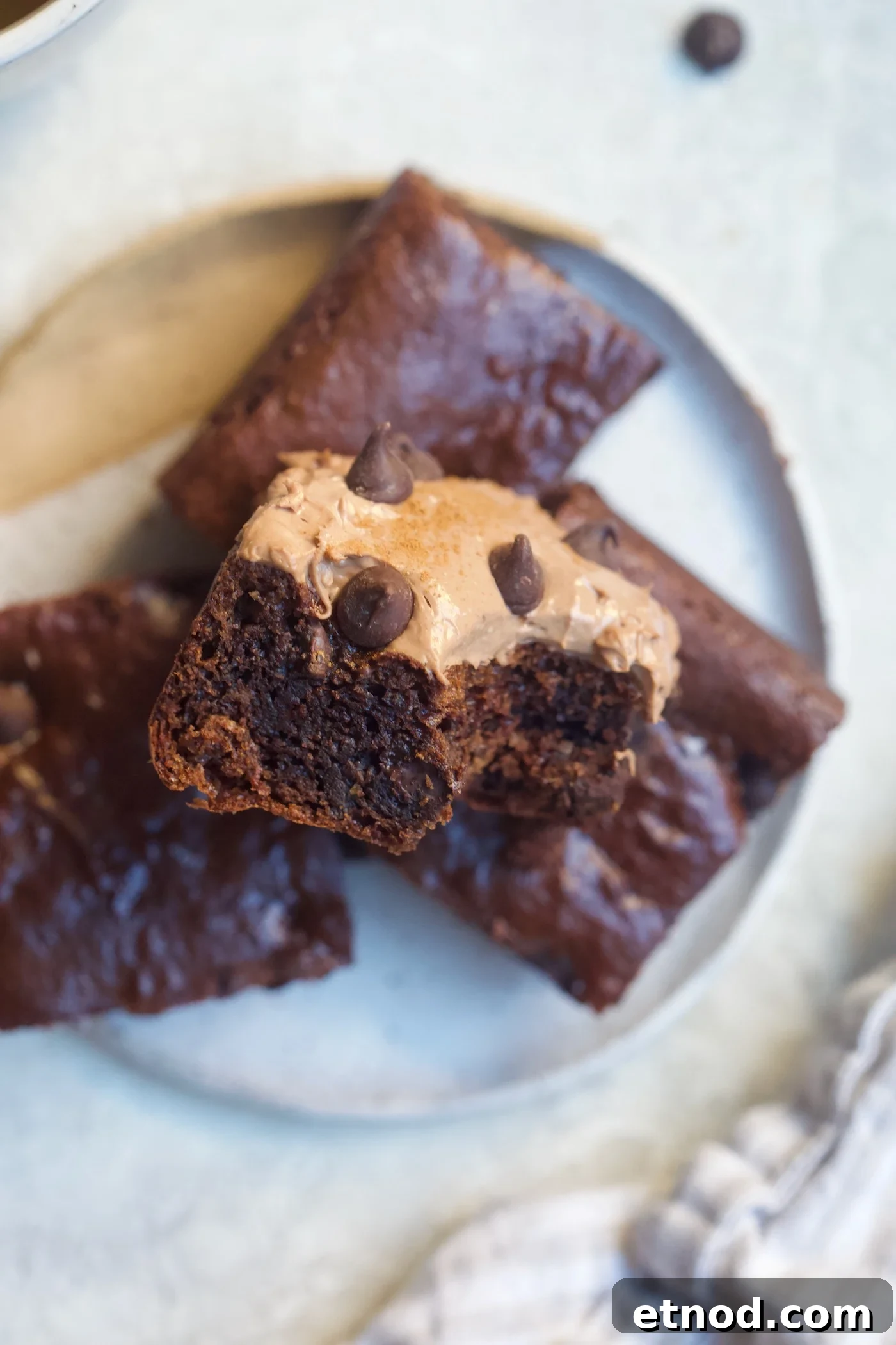 Chocolate Cream Cheese Frosting Recipe with Reduced Sugar 2 brownies on plate with chocolate frosting.