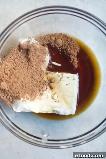 Chocolate Cream Cheese Frosting Recipe with Reduced Sugar 3 cream cheese and cocoa in bowl.