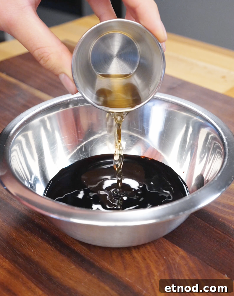 Soy-based fried rice sauce being poured into a bowl, combining dark soy sauce, light soy sauce, and seasonings.