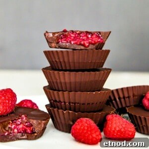 High-Protein Raspberry-Filled Chocolate Truffles 17 A stack of five chocolates and the top one has a bite out of it with raspberry filling spilling out of it.