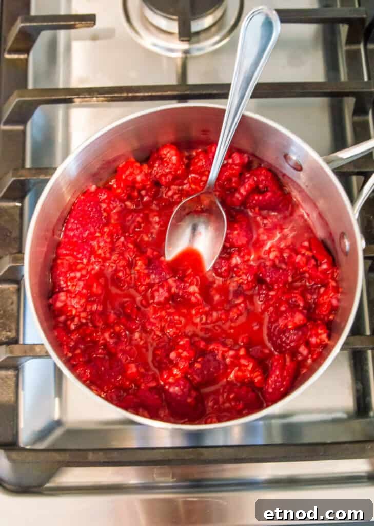 High-Protein Raspberry-Filled Chocolate Truffles 8 A saucepan on the stovetop with raspberries cooking in it.