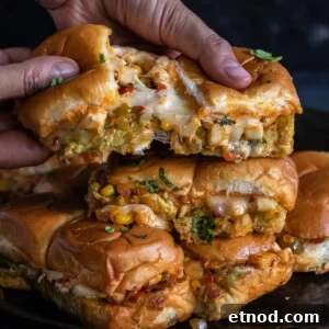 pair of hands pulling sliders apart to show the cheese pull