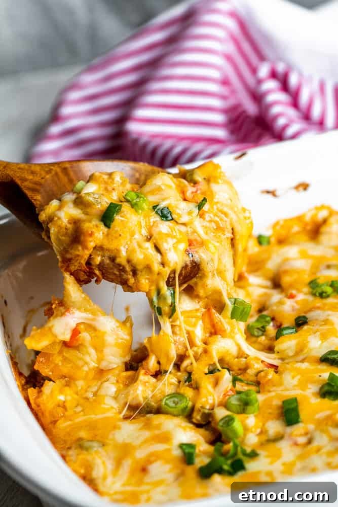 Creamy King Ranch Chicken Casserole Recipe for Family Dinners 7 Casserole being lifted out of baking dish with wooden spoon.