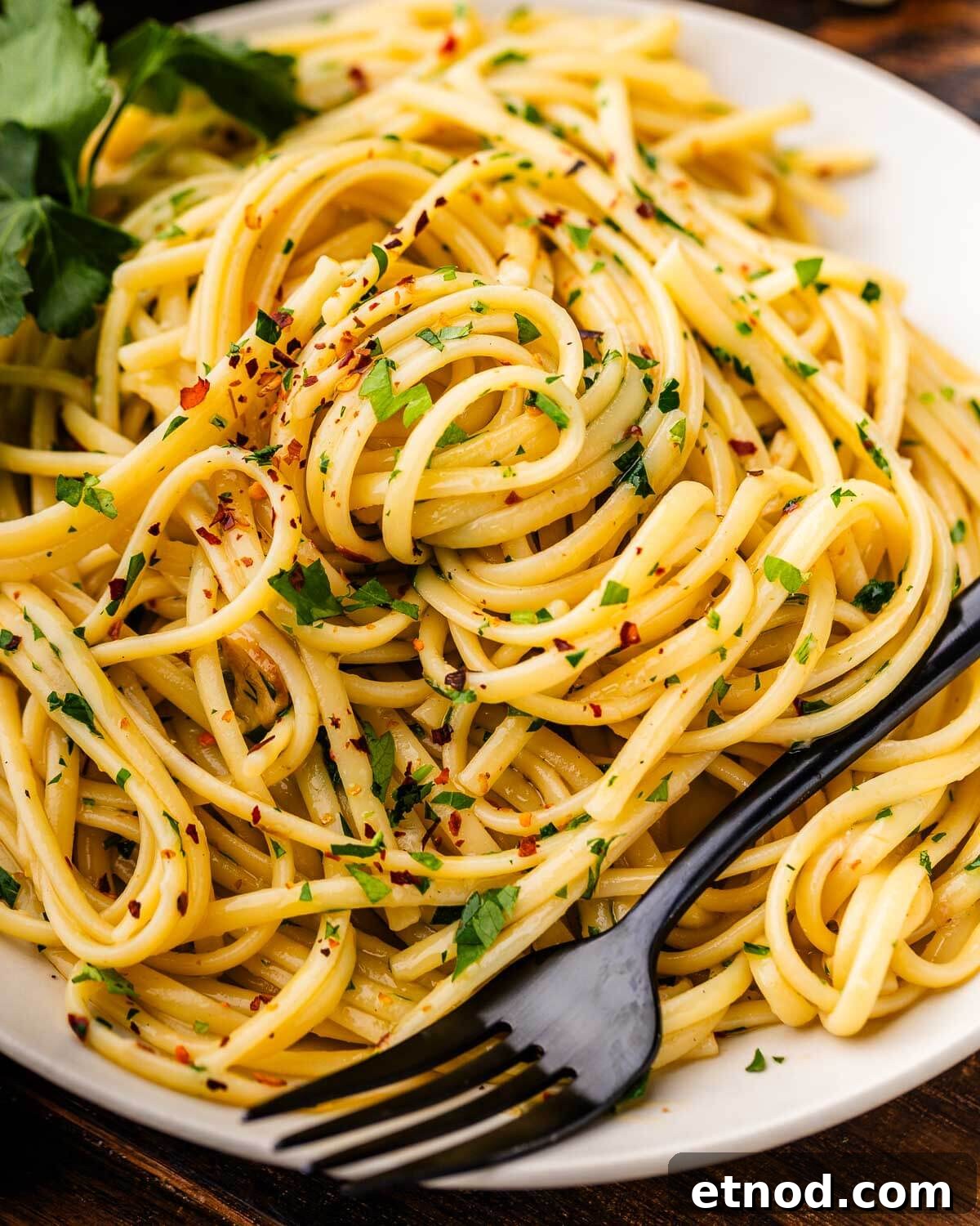 Linguine aglio e olio in white plate.