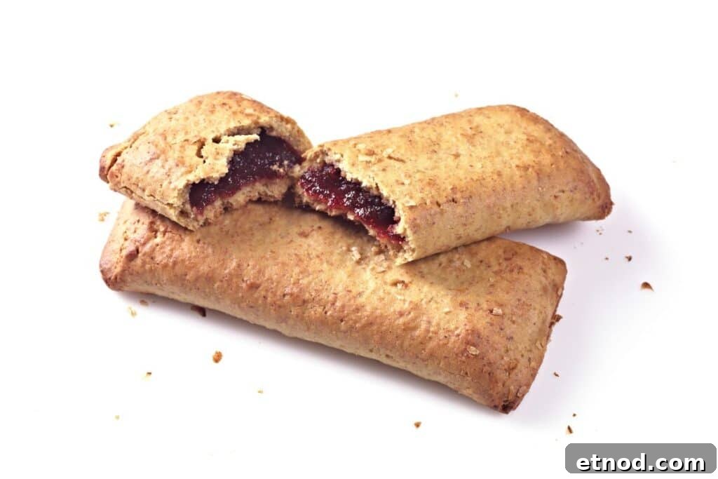 Two cereal bars with one broken in half on a white background.
