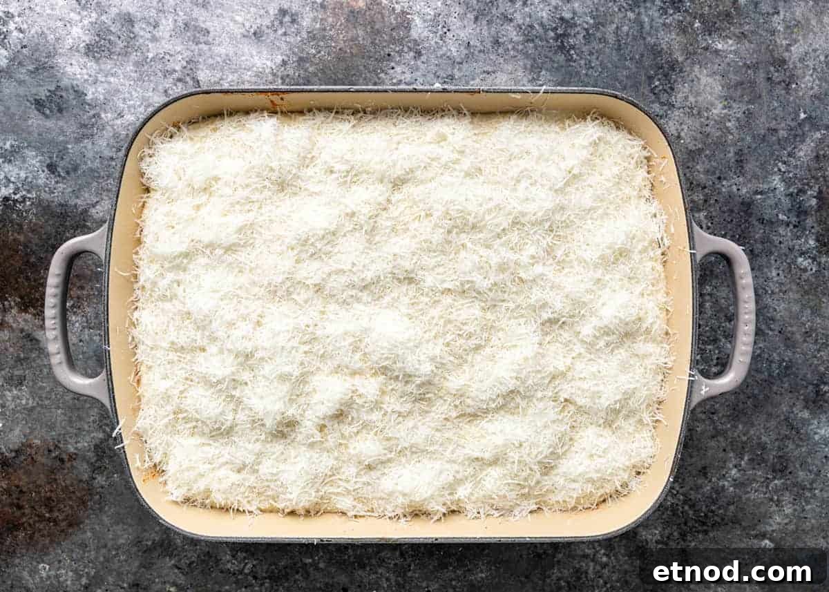 Authentic Greek Pastitsio Recipe: Classic Baked Pasta with Bechamel 13 overhead: layer of shredded kefalotyri cheese in baking dish for pastitsio recipe