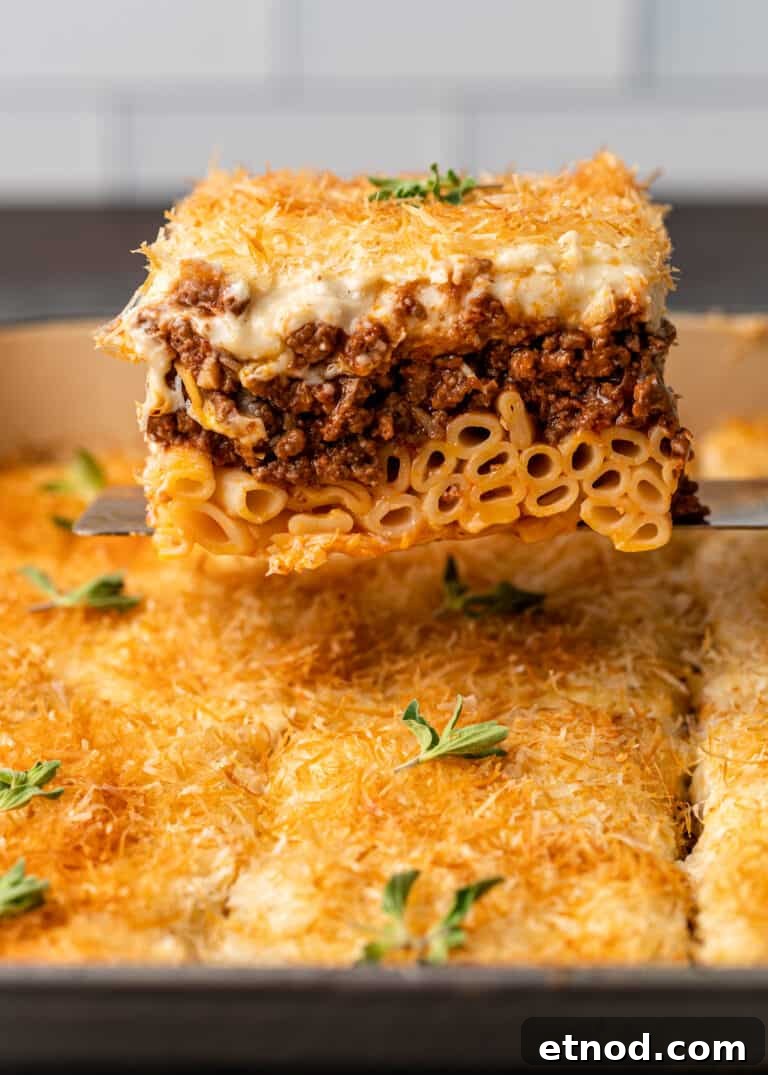 Authentic Greek Pastitsio Recipe: Classic Baked Pasta with Bechamel 4 large serving of my pastitsio recipe sits on spatula above the pan