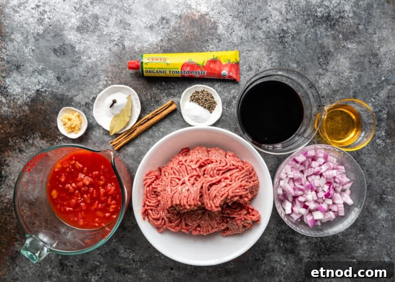Authentic Greek Pastitsio Recipe: Classic Baked Pasta with Bechamel 5 bowl with raw ground meat and smaller bowls of ingredients for pasticcio