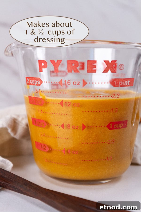a glass measuring cup with dressing in it.