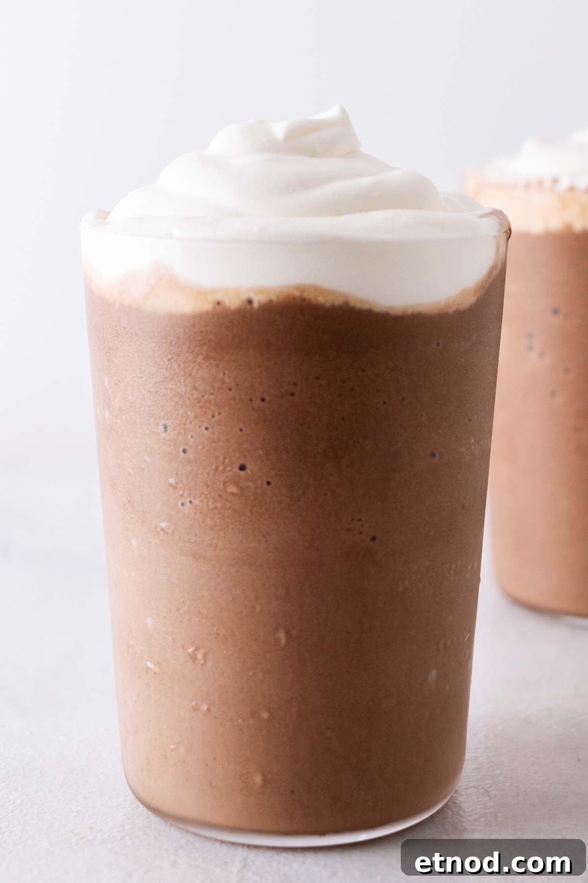 How to Make a Starbucks Mocha Frappuccino at Home 8 Mocha Frappuccino with whipped cream in a glass.