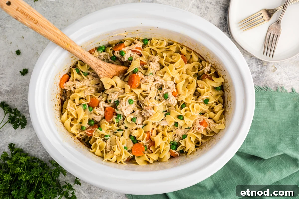 Creamy Slow Cooker Chicken and Noodles Recipe 7 noodles and chicken with peas and carrots in a slow cooker.