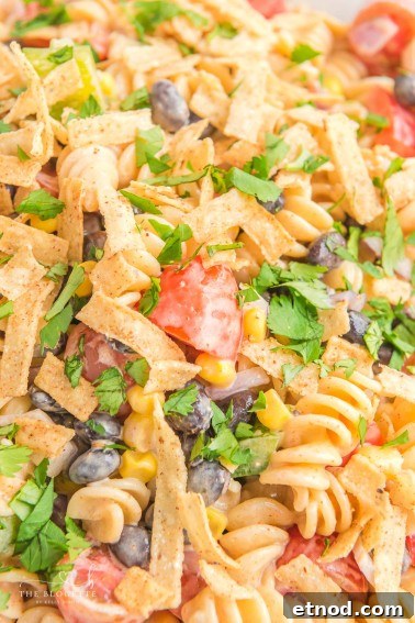 Creamy Ranch Taco Pasta Salad - Ranch dressing and taco seasoning folded into pasta with tomatoes, beans, corn, and more!