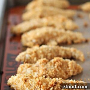 Crispy Caesar Chicken Tenders with Creamy Parmesan Dressing 3 Baked chicken tenders on rimmed baking sheet.