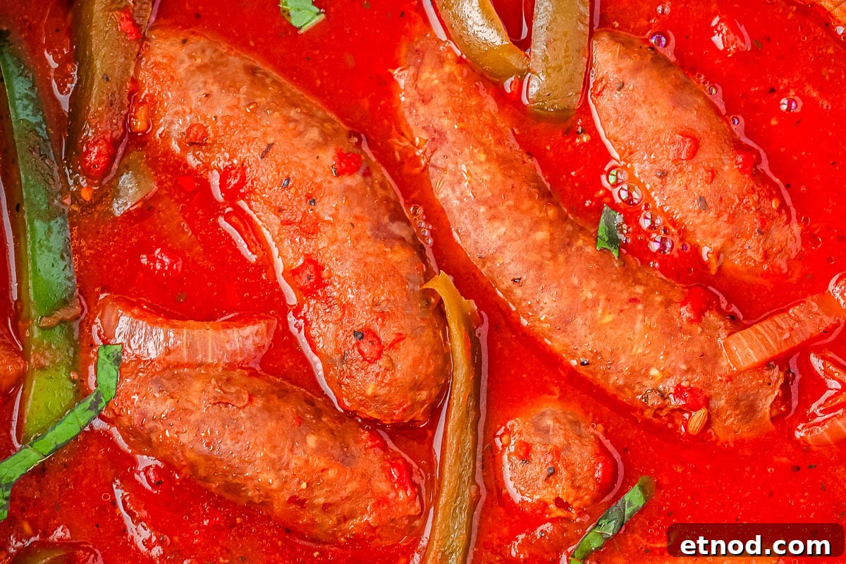 Slow Cooker Sausage and Peppers Recipe for Tender, Flavorful Meals 6 A close-up picture of 4 sausages in tomato sauce.