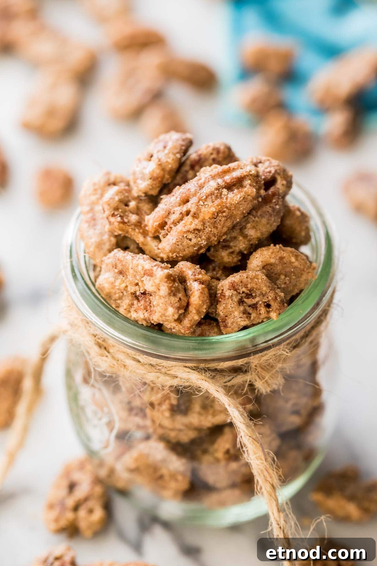 glass jar tied with twine filled with candied pecans
