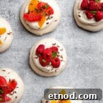 Mini pavlovas with dark chocolate on a countertop.