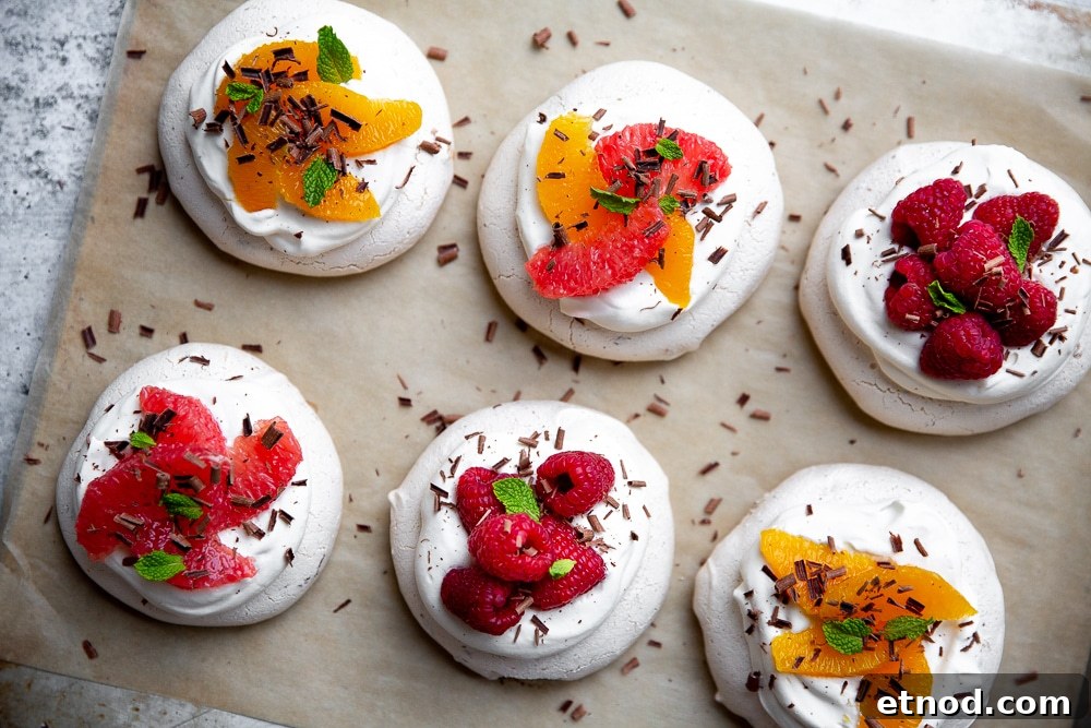 Overhead shot of mini pavlovas lined up on parchment paper.