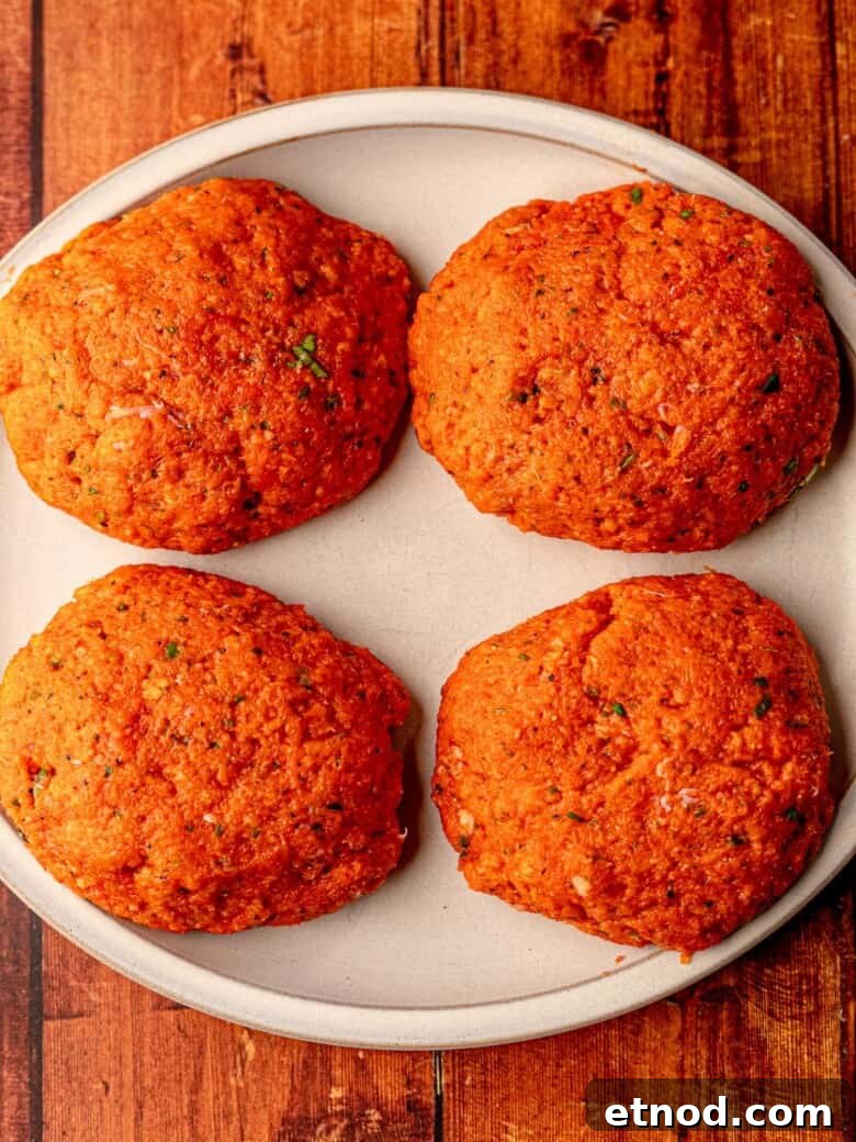 Crispy Baked Salmon Burgers with Lemon Dill Sauce 5 Salmon patties on a plate.