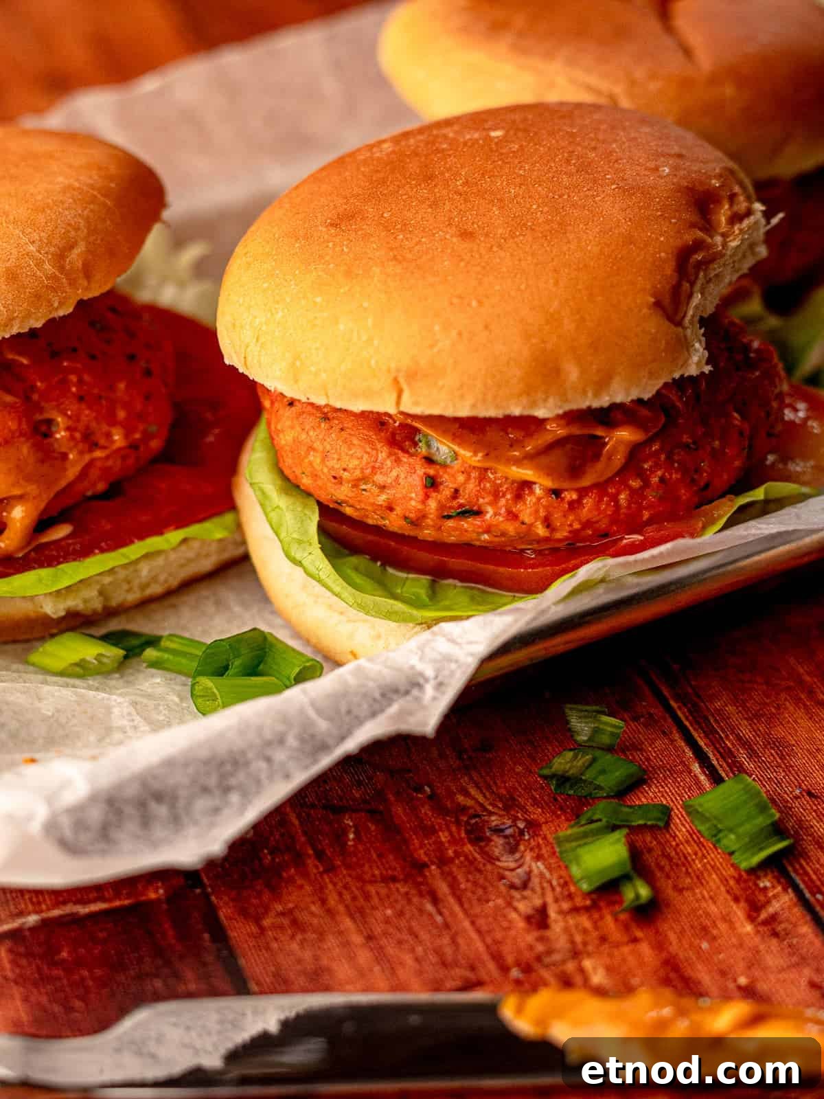Crispy Baked Salmon Burgers with Lemon Dill Sauce 7 A salmon burger with lettuce tomato on a tray.
