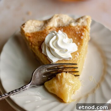 Slice of honey chess pie with a fork removing a slice.